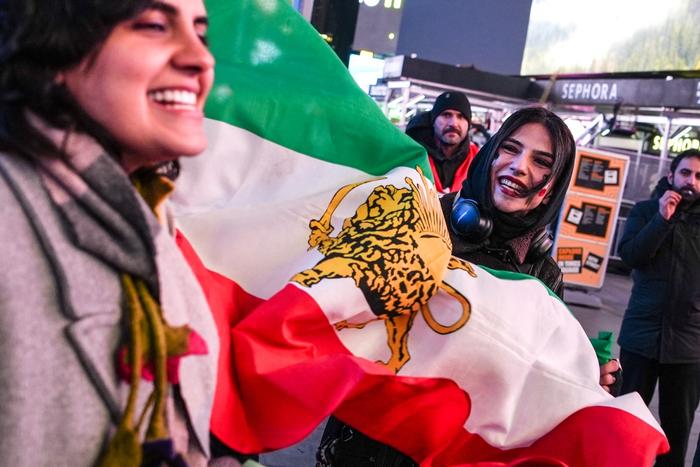 Une femme brandit un drapeau iranien d'avant la révolution islamique de 1979 lors d'une manifestation « Liberté pour l'Iran » en soutien au peuple iranien à New York, le 2 mars 2026.