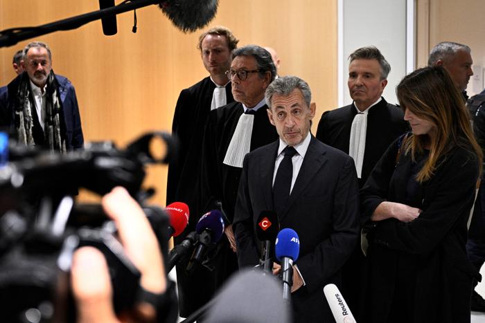 L'ancien président de la République Nicolas Sarkozy s'adresse à la presse entouré de son épouse Carla Bruni et de l'avocat Jean-Michel Darrois après le verdict de son procès pour financement illégal de campagne, au tribunal de Paris, le 25 septembre 2025.