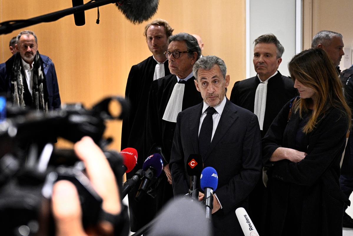 L'ancien président de la République Nicolas Sarkozy s'adresse à la presse entouré de son épouse Carla Bruni et de l'avocat Jean-Michel Darrois après le verdict de son procès pour financement illégal de campagne, au tribunal de Paris, le 25 septembre 2025.