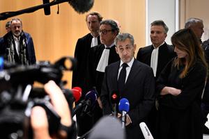 L'ancien président de la République Nicolas Sarkozy s'adresse à la presse entouré de son épouse Carla Bruni et de l'avocat Jean-Michel Darrois après le verdict de son procès pour financement illégal de campagne, au tribunal de Paris, le 25 septembre 2025.