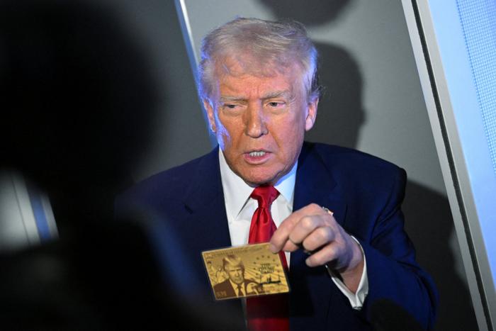 Le président américain Donald Trump montre la Gold Card à des journalistes alors qu'il est en vol à bord de l'Air Force One, le 3 avril 2025.