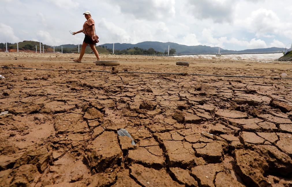 Lors du phénomène El Niño, une femme marche dans le réservoir asséché du Peñol de Guatapé, en Colombie, en mars 2024.