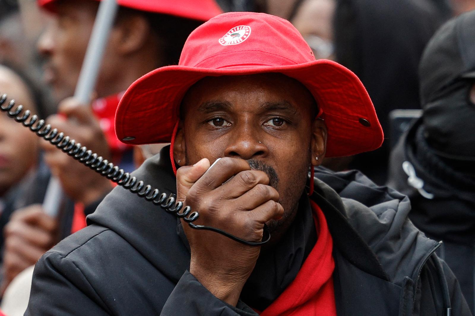 Rodrigue Petitot, dirigeant du Rassemblement pour la protection des peuples et des ressources afro-caribéens (RPPRAC), s’exprime au mégaphone lors d’une marche contre la vie chère organisée par les territoires d’outre-mer, place Denfert-Rochereau à Paris, le 3 novembre 2024.