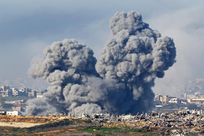 Cette image prise du côté israélien de la frontière avec la bande de Gaza montre des panaches de fumée s'élevant des explosions au-dessus des bâtiments détruits dans le nord de la bande de Gaza le 14 janvier 2025, dans le cadre de la guerre en cours entre Israël et le Hamas.