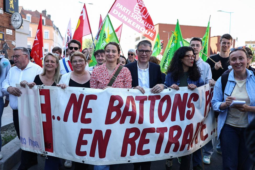 Marine Tondelier, secrétaire nationale des Écologistes, et Olivier Faure, premier secrétaire du Parti socialiste (PS), brandissent une banderole lors d'un rassemblement pour le 1er mai, marquant la Journée internationale des travailleurs, à Dunkerque, le 1er mai 2025.