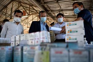 Des représentants du gouvernement examinent des médicaments illégaux et des articles contrefaits saisis lors d'une cérémonie de destruction de 130 tonnes de produits de contrefaçon à Phnom Penh, le 4 juin 2020.