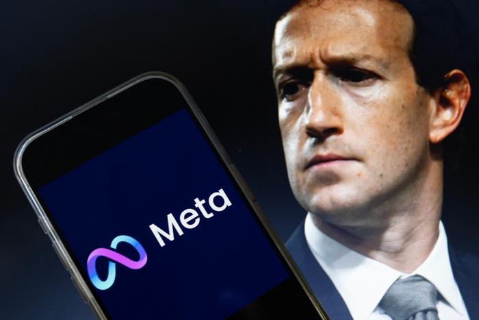 Le logo de Meta est affiché sur un téléphone devant un portait de Mark Zuckerberg (image d'illustration).