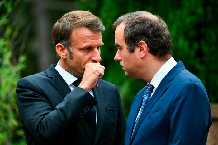 Emmanuel Macron s'entretient avec Sébastien Lecornu, lors d'une cérémonie marquant le 80e anniversaire du débarquement allié en Provence pendant la Seconde Guerre mondiale, au cimetière national de Boulouris à Boulouris-sur-Mer, le 15 août 2024.