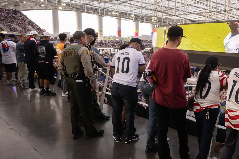 Des adjoints du shérif du comté de Los Angeles se tiennent au milieu des supporters au stade de Los Angeles (SoFi Stadium) lors du match de la Coupe du monde de la FIFA 2026 entre les États-Unis et le Paraguay à Inglewood, en Californie, le 12 juin 2026.