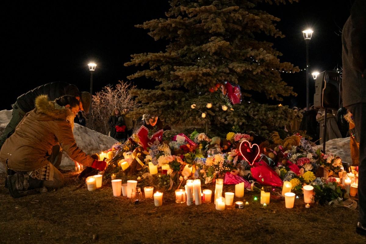 Un membre de la communauté locale dépose des fleurs lors d'une veillée aux chandelles en hommage aux victimes de la fusillade survenue la veille à l'école secondaire Tumbler Ridge, en Colombie-Britannique, le 11 février 2026.
