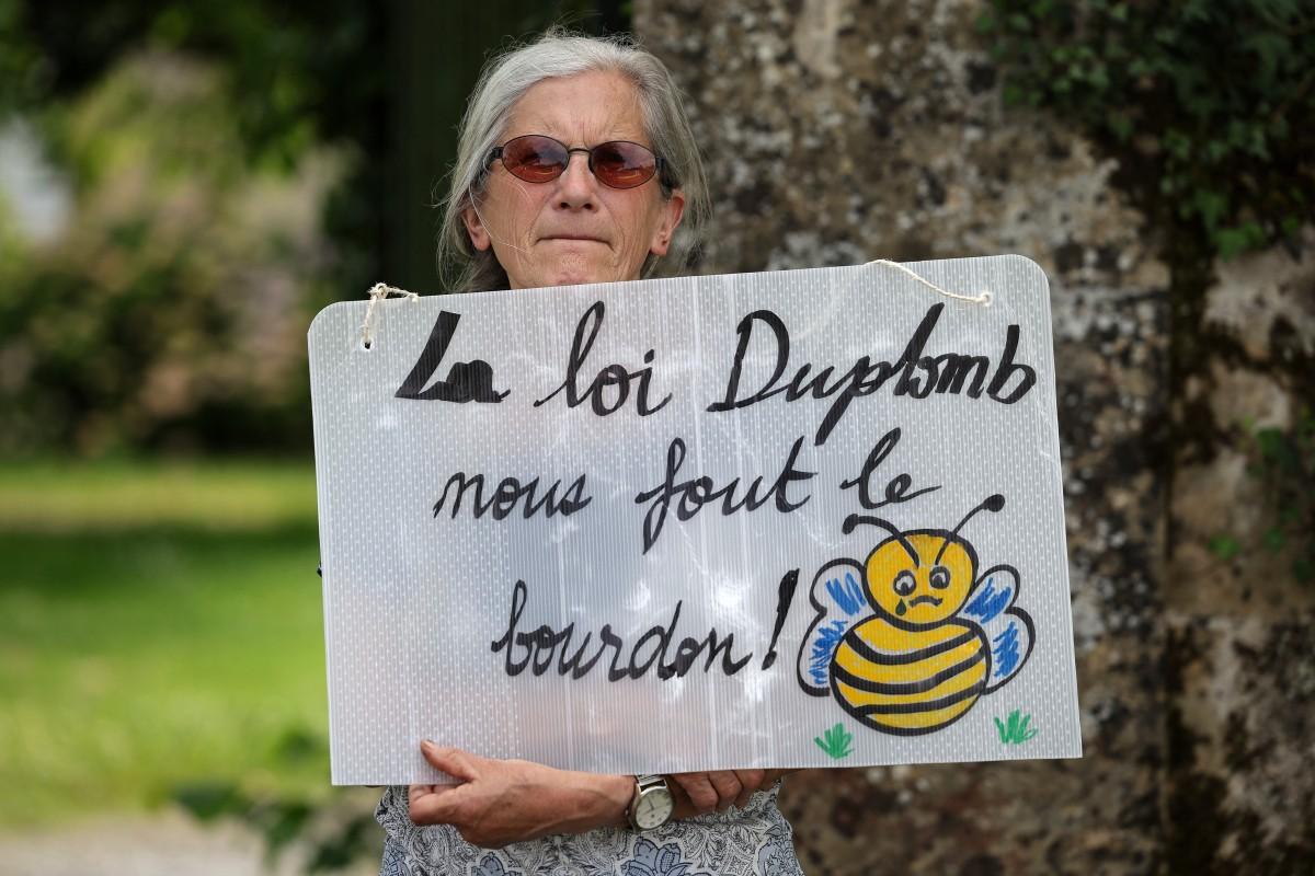 Un membre de la Confédération paysanne, syndicat agricole français, tient une pancarte sur laquelle on peut lire « La loi Duplomb nous donne le blues », le 5 juin 2025.