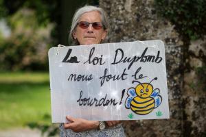 Un membre de la Confédération paysanne, syndicat agricole français, tient une pancarte sur laquelle on peut lire « La loi Duplomb nous donne le blues », le 5 juin 2025.