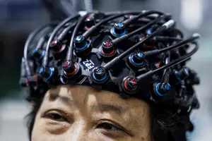 Une femme portant un appareil de surveillance cérébrale de la société chinoise Yiruide Group lors de l'Exposition mondiale de la santé 2024 à Wuhan, dans la province du Hubei, en Chine.