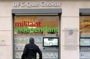 Un homme regarde la vitrine du siège de la principale association française de défense des consommateurs, l'UFC-Que Choisir, le 25 mars 2014 à Paris.