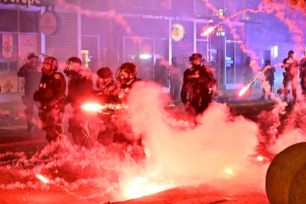 Manifestation à Little Tokyo (Los Angeles), le 9 juin 2025 : des feux d’artifice éclatent autour de policiers en tenue antiémeute, alors que l’administration Trump déploie 700 Marines et plusieurs milliers de soldats de la Garde nationale, déclenchant la colère du gouverneur de Californie. Les protestations, débutées le 6 juin après des rafles de l’ICE ciblant migrants en situation irrégulière et membres de gangs, se sont intensifiées dans ce quartier à forte population latino-américaine.