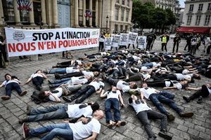 Des militants de l'association ANV-COP 21 pour le Climat organisent un « die-in » sous une banderole alors qu'ils participent à une manifestation pour dénoncer la qualité de l'air le 4 juin 2019 devant l'Assemblée nationale à Paris.(Image d'illustration)