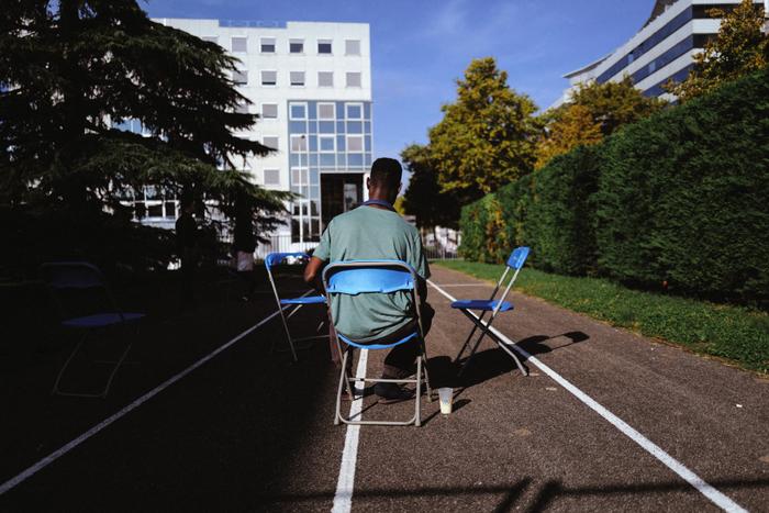 Un jeune migrant est assis dans l'enceinte du gymnase Marcel Dargent où il est hébergé à Lyon, dans l'est de la France.