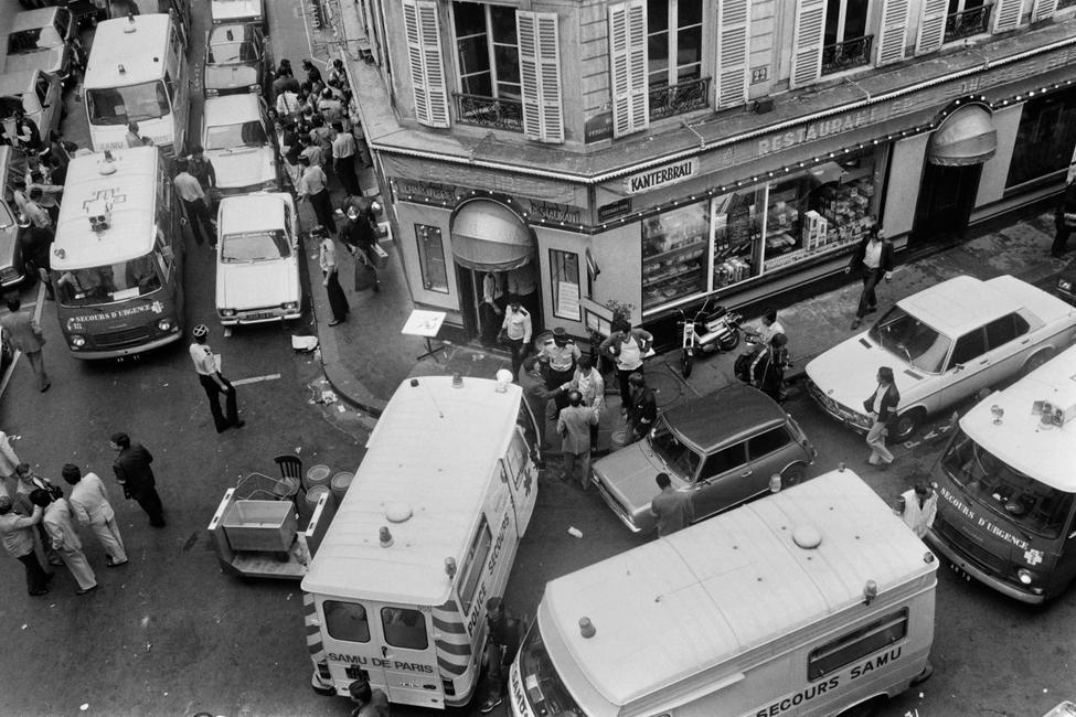 Vue des pompiers et des secouristes rue des Rosiers après l'attaque du restaurant traiteur franco-juif Jo Goldenberg, le 9 août 1982 à Paris. Des hommes armés ont lancé une grenade dans le restaurant et ouvert le feu sur les clients avec des mitraillettes, tuant six clients et en blessant 22 autres. (Photo de Jacques DEMARTHON / AFP)