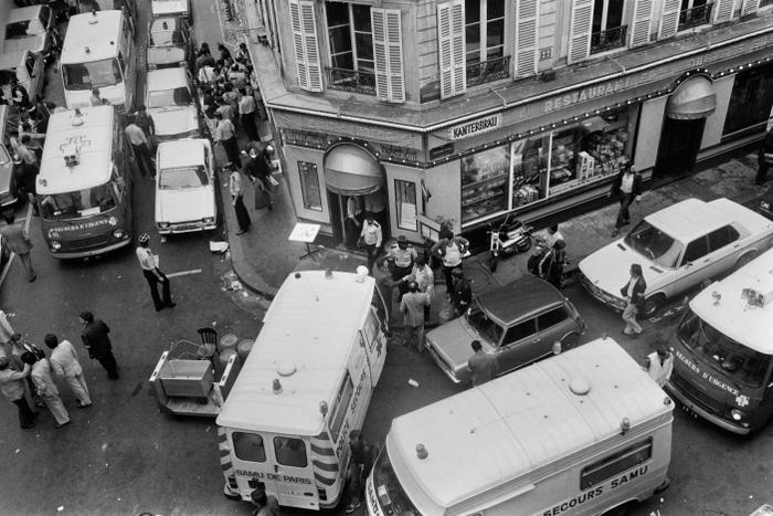 Vue des pompiers et des secouristes rue des Rosiers après l'attaque du restaurant traiteur franco-juif Jo Goldenberg, le 9 août 1982 à Paris. Des hommes armés ont lancé une grenade dans le restaurant et ouvert le feu sur les clients avec des mitraillettes, tuant six clients et en blessant 22 autres. (Photo de Jacques DEMARTHON / AFP)