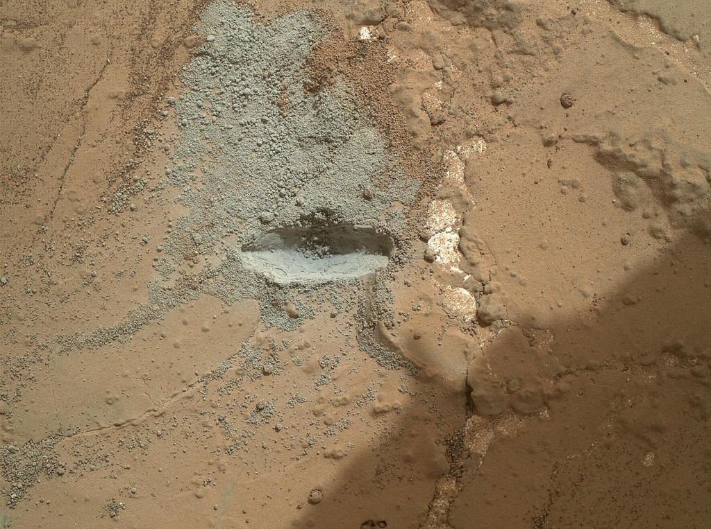 Cette image, fournie par la NASA montre l'empreinte laissée par le foret à percussion rotatif du rover Curiosity sur la roche « John Klein », lors d'un test effectué, en préparation du premier forage de roche par le rover.