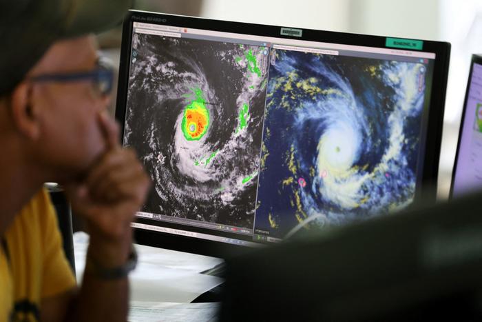 Un prévisionniste regarde des écrans de contrôle alors qu'il surveillent le cyclone Freddy à la station météorologique française, Météo France, à Saint-Denis de la Réunion, le 20 février 2023.