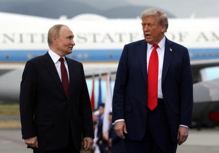 Le président américain Donald Trump et son homologue russe Vladimir Poutine discutent et posent pour les photographes après leur arrivée à la base militaire conjointe Elmendorf-Richardson d'Anchorage, en Alaska, le 15 août 2025, pour un sommet américano-russe sur l'Ukraine. 