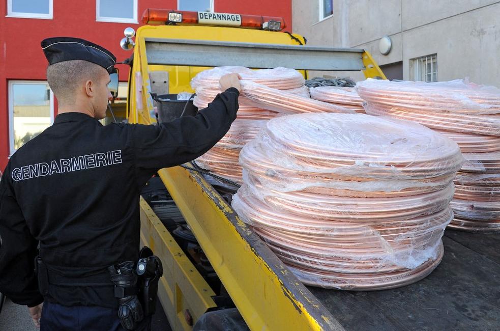 Un gendarme examine plusieurs tonnes de câbles de cuivre volés, saisis dans un campement rom à Montpellier.