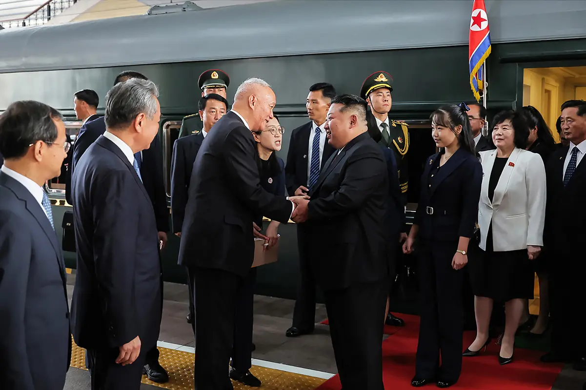 Le dirigeant nord-coréen Kim Jong Un (au centre, à droite) et sa fille Kim Ju Ae (3e à droite) accueillis par Cai Qi (au centre, à gauche), secrétaire du Secrétariat central du Parti communiste chinois, et le ministre des Affaires étrangères Wang Yi (2e à gauche), à leur arrivée à la gare ferroviaire de Pékin. Kim est arrivé dans la capitale chinoise à bord d’un train blindé le 2 septembre 2025.