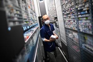 Cette photographie, prise le 19 octobre 2022, montre un pharmacien récupérant une boîte de médicaments sur une étagère d'une pharmacie parisienne.