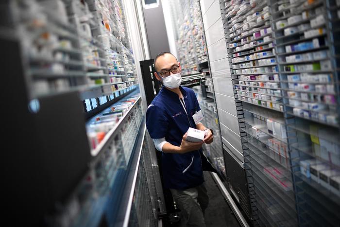 Cette photographie, prise le 19 octobre 2022, montre un pharmacien récupérant une boîte de médicaments sur une étagère d'une pharmacie parisienne.