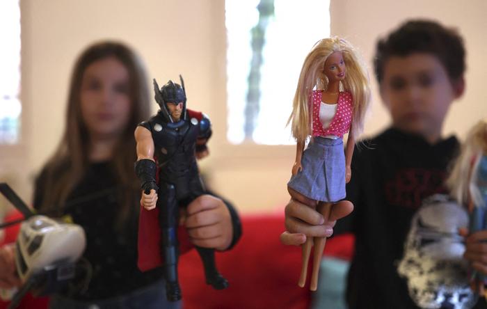 Des enfants jouent avec des poupées et des jouets. 