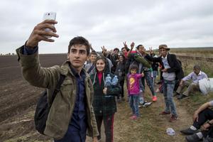 Alvand, 18, from Kobani, Syria takes a selfie with his friends as they walk along a railway track after crossing into Hungary from the border with Serbia near the village of Roszke September 5, 2015.