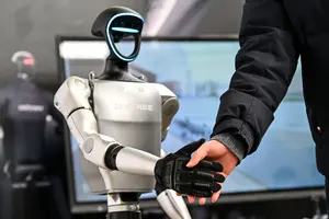 Un homme serre la main d'un robot humanoïde d'Unitree Robotics lors de la Global Developer Conference, organisée par la Shanghai AI Industry Association, à Shanghai, le 21 février 2025. (Image d'illustration)