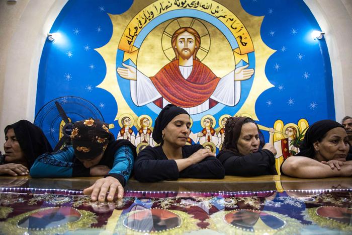 Des familles prient et pleurent devant les dépouilles rapatriées de 20 chrétiens coptes orthodoxes égyptiens, décapités par des djihadistes fidèles à l'État islamique, lors de leurs funérailles à l'église des Martyrs du village d'Al-Our, dans la province de Minya, au sud de l'Égypte, le 15 mai 2018.