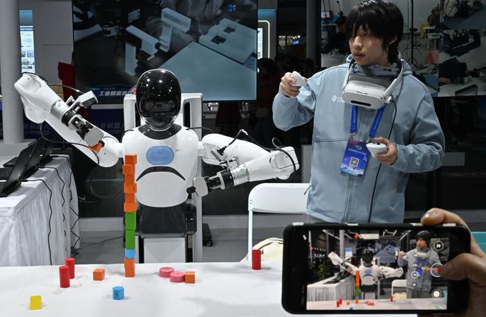 Un ingénieur contrôle un robot de la société Tashan lors du Carnaval de science-fiction de Pékin, le 28 mars 2026.