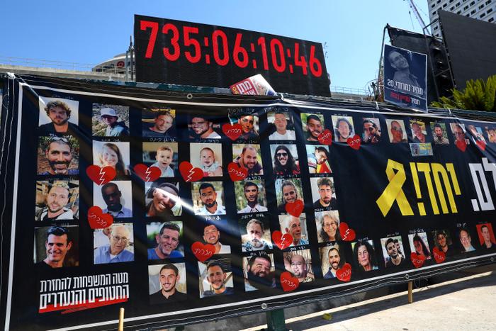 Des portraits d'otages israéliens retenus captifs dans la bande de Gaza depuis les attentats du 7 octobre 2023 sont exposés sous une horloge numérique indiquant les jours, les heures et les minutes de leur captivité, devant le Musée d'art de Tel-Aviv, surnommé la « Place des otages », à Tel-Aviv, en Israël, le 11 octobre 2025.