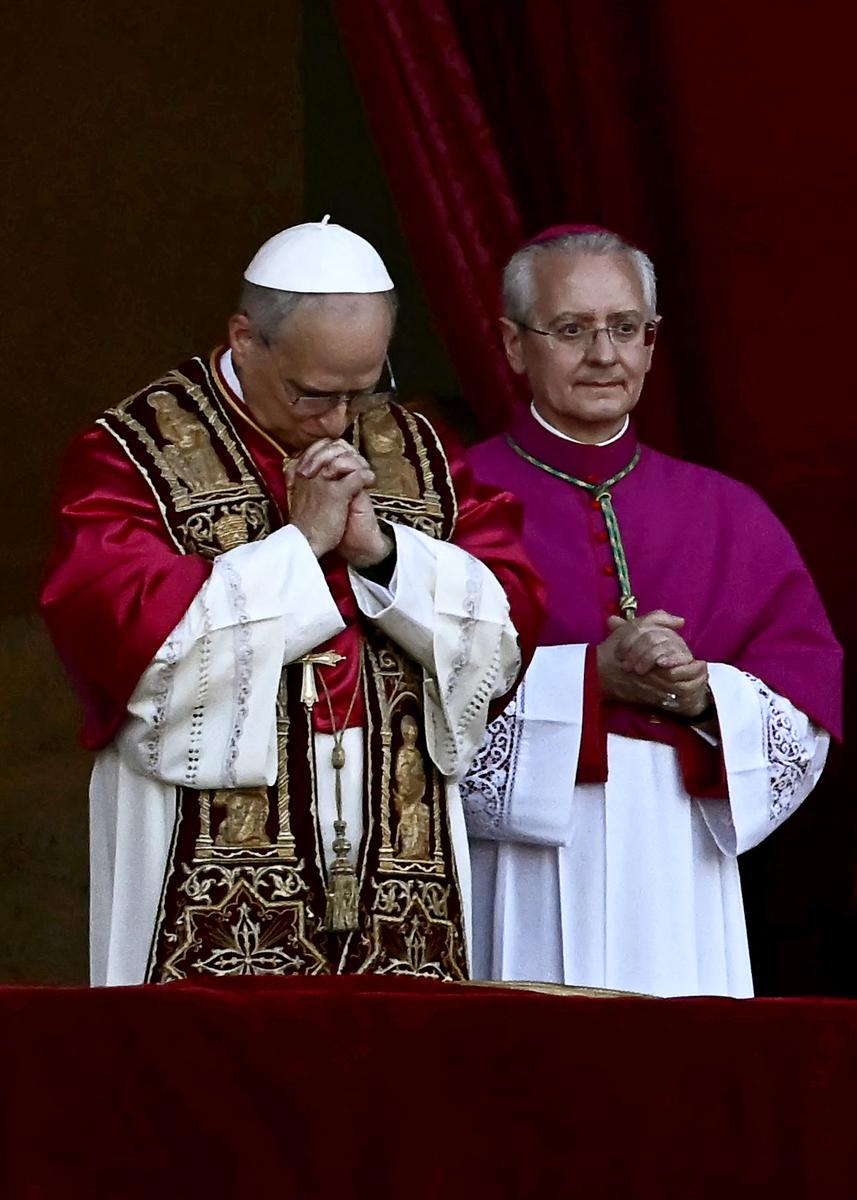 Le nouveau pape élu, Léon XIV, Robert Prevost (à gauche), fait un geste depuis le balcon central principal de la basilique Saint-Pierre, au Vatican, le 8 mai 2025, lors de sa première apparition après la fin du conclave des cardinaux.
Robert Francis Prevost a été élu jeudi, devenant ainsi le premier pape originaire des États-Unis, a annoncé le Vatican.
Modéré, proche du pape François et ancien missionnaire pendant plusieurs années au Pérou, il devient le 267e pontife de l’Église catholique, prenant le nom pontifical de Léon XIV.