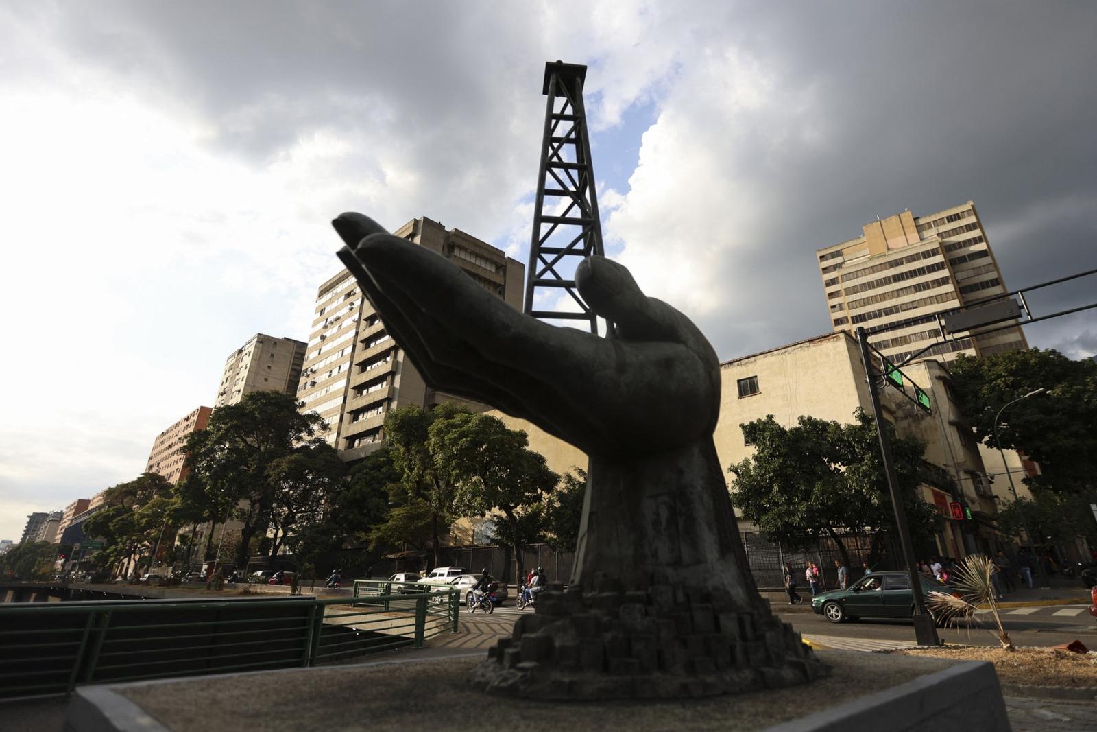 Une sculpture représentant une main tenant une plateforme de forage pétrolier est visible devant le siège de la compagnie pétrolière nationale vénézuélienne Petróleos de Venezuela SA (PDVSA) à Caracas, le 26 février 2025.