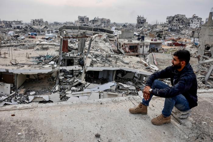 Un Palestinien sur le site d'un immeuble endommagé, surplombant les décombres du quartier de Tel al-Hawa, au sud de Gaza, le 29 novembre 2025.