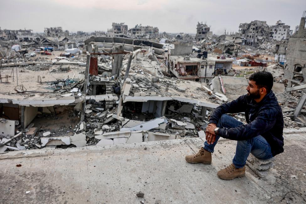 Un Palestinien sur le site d'un immeuble endommagé, surplombant les décombres du quartier de Tel al-Hawa, au sud de Gaza, le 29 novembre 2025.