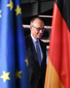Le chancelier allemand Friedrich Merz apparaît entre un drapeau allemand (à droite) et un drapeau européen alors qu’il arrive pour donner une conférence de presse. (Image d'illustration)