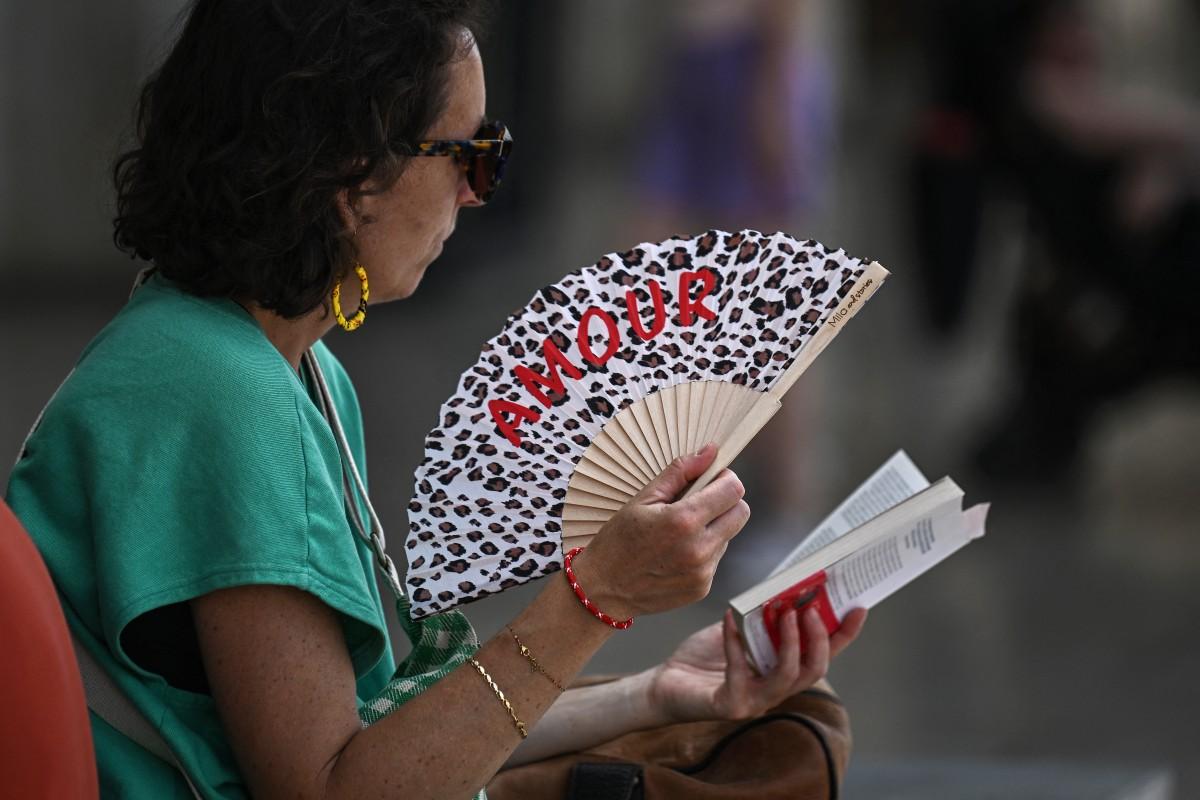 Une passagère utilise un ventilateur pour se rafraîchir en attendant son train à la gare de Saint-Jean, à Bordeaux.