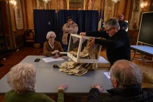 Des fonctionnaires vident une urne après la fermeture des bureaux de vote lors des élections municipales à la mairie de Perpignan, le 15 mars 2026.