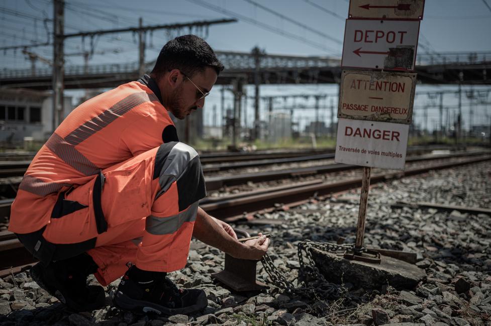 Un employé de la SNCF vérifie la température des voies ferrées devant la gare de Bordeaux, alors qu'une vague de chaleur frappe la France.