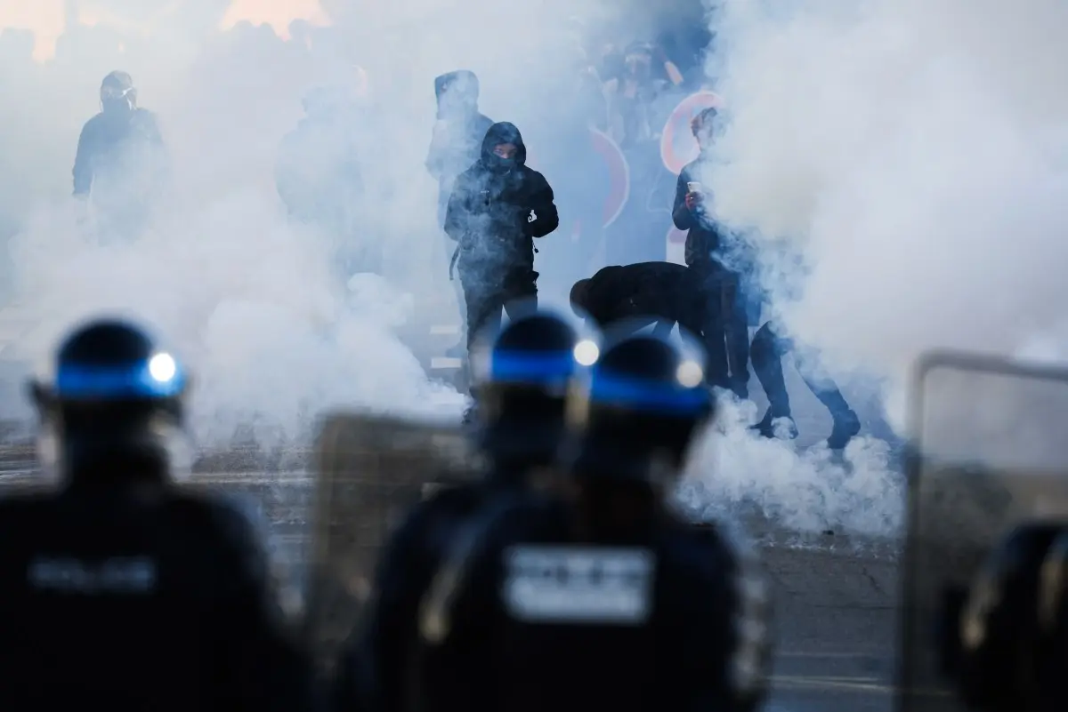 Des policiers se tiennent face à des manifestants au milieu des gaz lacrymogènes, alors que des élèves bloquent les abords du lycée Kerichen à Brest, dans l'ouest de la France, le 2 octobre 2026.