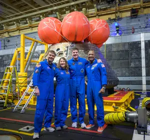 Photo fournie par la NASA montrant (de gauche à droite) les astronautes de la NASA Reid Wiseman, commandant, Christina Koch, spécialiste de mission, l’astronaute de l’Agence spatiale canadienne Jeremy Hansen, spécialiste de mission, et l’astronaute de la NASA Victor Glover, pilote de la mission Artemis II, posant pour une photo de groupe après avoir observé le vaisseau Orion dans le radier du USS John P. Murtha, le 11 avril 2026, dans l’océan Pacifique, au large des côtes de la Californie. Le quatuor a amerri le 10 avril à 17 h 07 (heure du Pacifique), soit 20 h 07 (heure de l’Est).
