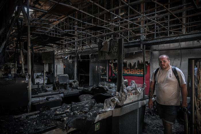 Le gérant d'un magasin Carrefour Market inspecte les dégâts après qu'un magasin ait été incendié au milieu d'émeutes contre la hausse des prix, à Le François, près de Fort-de-France sur l'île de la Martinique, le 17 octobre 2024.