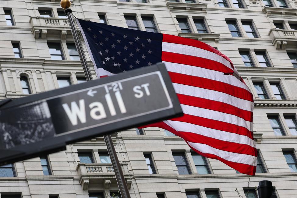 Le drapeau américain flotte derrière un panneau « Wall Street » près de la Bourse de New York (NYSE), à New York, le 22 avril 2026.