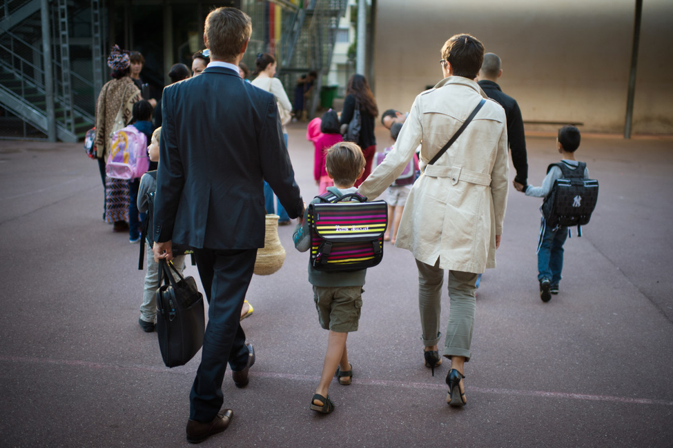 Des parents emmènent leurs enfants à l'école à Paris.