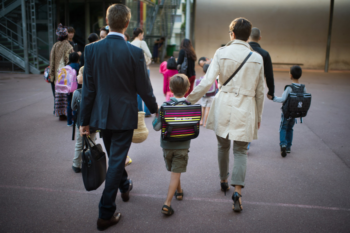 Des parents emmènent leurs enfants à l'école à Paris.